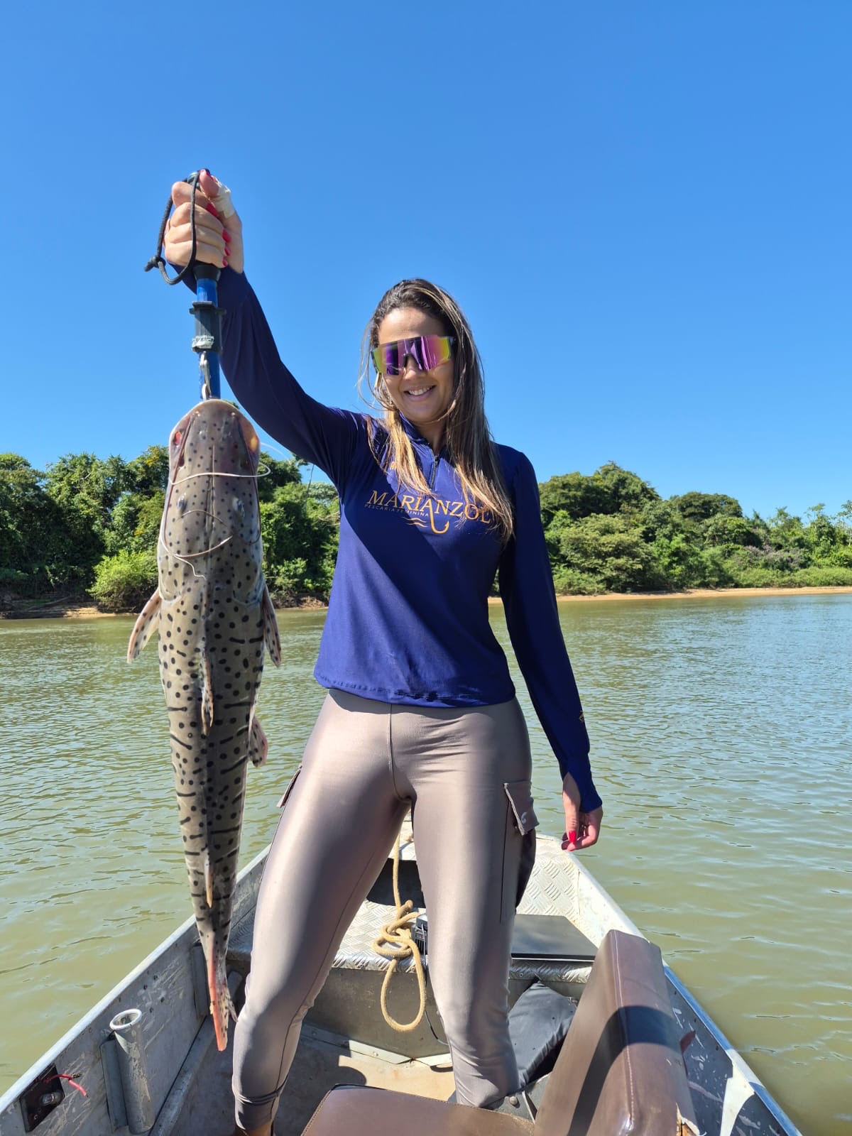 Mulher pescando em um barco sob céu azul